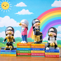 Four animated character figurines standing on books with a colorful background featuring a sun, rainbow, and clouds.
