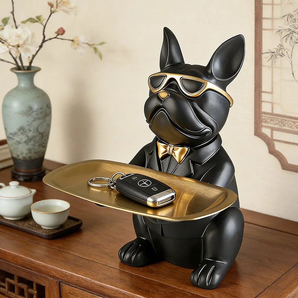 Black dog figurine with sunglasses and a tray on a wooden surface