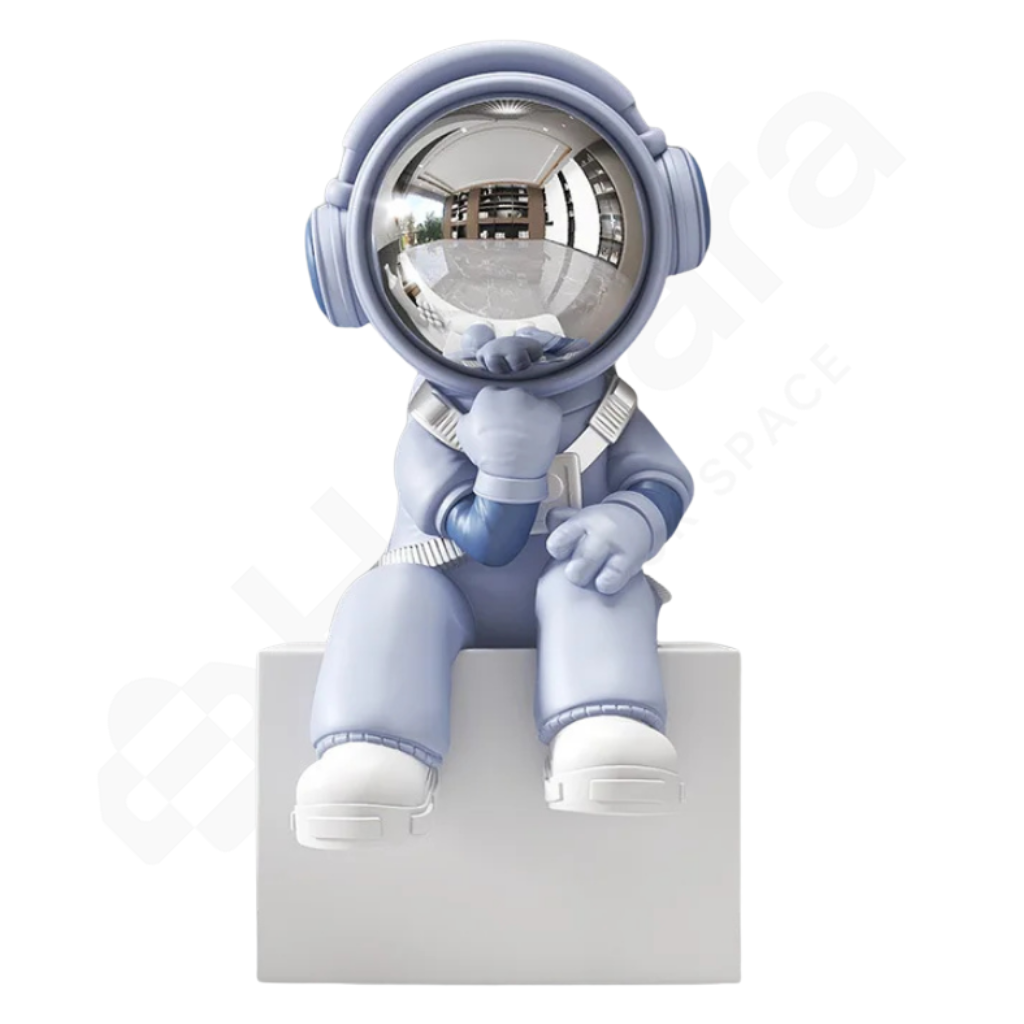 Blue astronaut figurine sitting on a white block against a white background