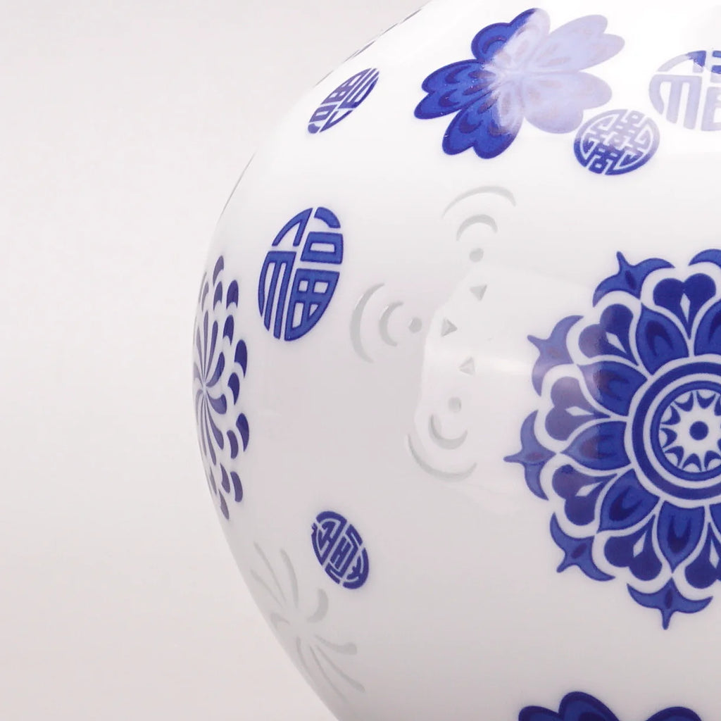 White ceramic jar with blue floral and circular patterns on a white background