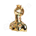 Gold figurine with floral design on a white background