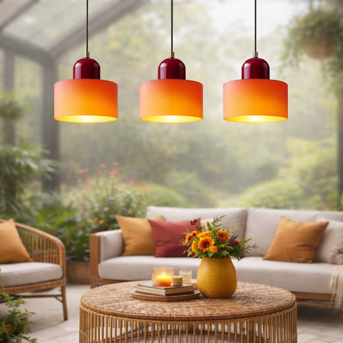 Outdoor patio with orange pendant lights, a sofa, and a coffee table with a candle and flowers.