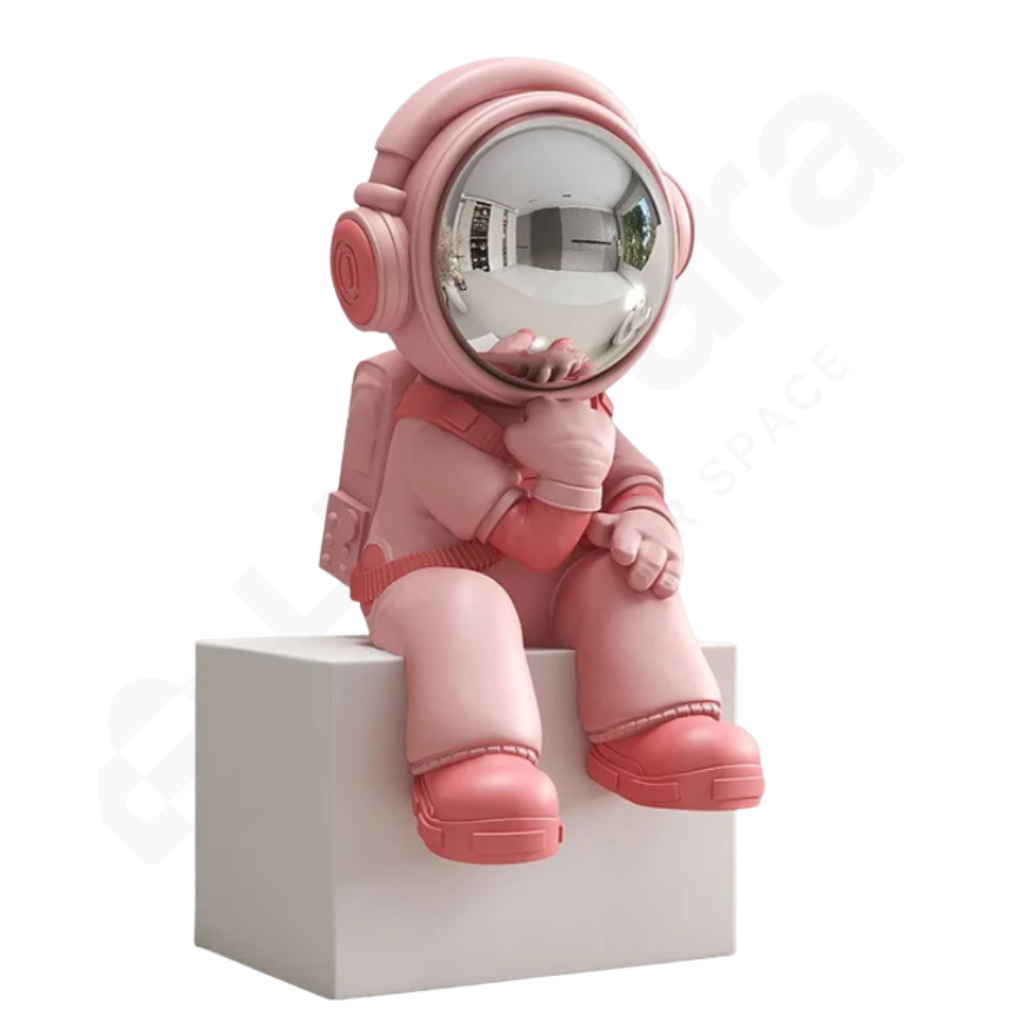 Pink astronaut figurine sitting on a white block against a white background