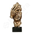 Bronze sculpture of a face with a hand over it on a white background